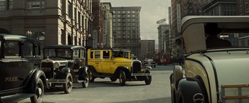 Movie still from “Changeling” (2008), directed by Clint Eastwood – An old yellow car driving down the street; Wide shot, Low angle