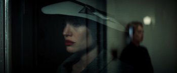 Movie still from “Changeling” (2008), directed by Clint Eastwood – A woman wearing a white hat looking out of a window; Close Up shot, Over the shoulder angle