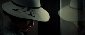 Movie still from “Changeling” (2008), directed by Clint Eastwood – A woman wearing a white hat with a bow on it's brim; Extreme Close Up shot, Low angle