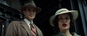 Movie still from “Changeling” (2008), directed by Clint Eastwood – A man and a woman wearing hats and suits; Close Up shot, Low angle