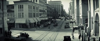 Movie still from “Changeling” (2008), directed by Clint Eastwood – A black and white photo of a city street; Extreme Wide shot, High angle