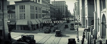 Movie still from “Changeling” (2008), directed by Clint Eastwood – A black and white photo of a city street; Extreme Wide shot, Overhead angle