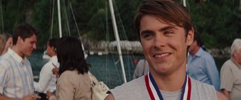 Movie still from “Charlie St. Cloud” (2010), directed by Burr Steers – A young man smiling while standing next to a boat; Close Up shot, Over the shoulder angle