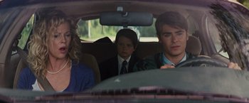 Movie still from “Charlie St. Cloud” (2010), directed by Burr Steers – Three people sitting in a car looking out of the window; Medium shot, Over the shoulder angle