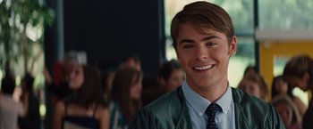 Movie still from “Charlie St. Cloud” (2010), directed by Burr Steers – A person wearing a suit and tie smiling; Close Up shot, Over the shoulder angle