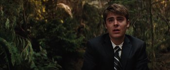 Movie still from “Charlie St. Cloud” (2010), directed by Burr Steers – A man in a suit and tie in front of a forest; Close Up shot, Over the shoulder angle