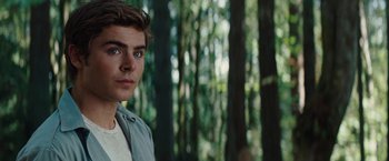 Movie still from “Charlie St. Cloud” (2010), directed by Burr Steers – A man standing in the middle of a forest with trees in the background; Close Up shot, Over the shoulder angle