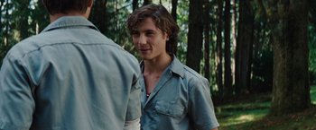Movie still from “Charlie St. Cloud” (2010), directed by Burr Steers – A young man in a blue shirt is standing in the woods; Close Up shot, Over the shoulder angle