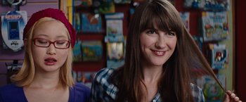 Movie still from “Charlie St. Cloud” (2010), directed by Burr Steers – A woman with long brown hair and bangs smiles for the camera; Close Up shot, Over the shoulder angle