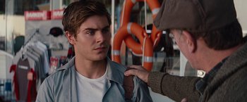Movie still from “Charlie St. Cloud” (2010), directed by Burr Steers – A man is being held by another man in front of an orange life preserver; Close Up shot, Over the shoulder angle