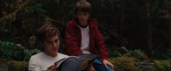 Movie still from “Charlie St. Cloud” (2010), directed by Burr Steers – Two young men sitting on the ground reading a book; Medium shot, Over the shoulder angle