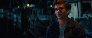 Movie still from “Charlie St. Cloud” (2010), directed by Burr Steers – A young man is looking into the distance while standing in front of a building; Close Up shot, Over the shoulder angle