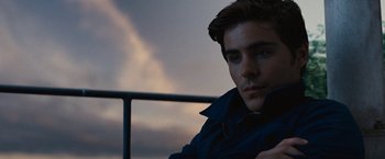 Movie still from “Charlie St. Cloud” (2010), directed by Burr Steers – A young man sitting on top of a railing looking at the camera; Close Up shot, Over the shoulder angle