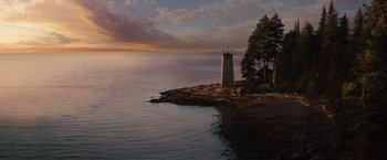Movie still from “Charlie St. Cloud” (2010), directed by Burr Steers – A lighthouse on the edge of a body of water at sunset; Extreme Wide shot, High angle