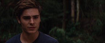 Movie still from “Charlie St. Cloud” (2010), directed by Burr Steers – A young man is standing in front of some trees; Close Up shot, Over the shoulder angle