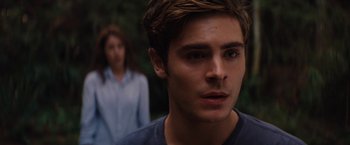 Movie still from “Charlie St. Cloud” (2010), directed by Burr Steers – A man and a woman standing next to each other in front of trees; Close Up shot, Over the shoulder angle