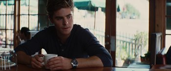Movie still from “Charlie St. Cloud” (2010), directed by Burr Steers – A man sitting at a table with a cup of coffee; Medium shot, Over the shoulder angle