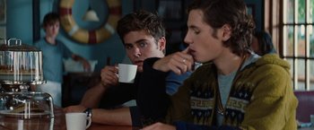 Movie still from “Charlie St. Cloud” (2010), directed by Burr Steers – Two young men sitting at a table drinking coffee; Medium shot, Over the shoulder angle