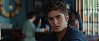 Movie still from “Charlie St. Cloud” (2010), directed by Burr Steers – A man in a black shirt is looking at the camera; Close Up shot, Over the shoulder angle