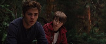 Movie still from “Charlie St. Cloud” (2010), directed by Burr Steers – Two young men sitting next to each other in the woods; Close Up shot, Over the shoulder angle