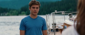 Movie still from “Charlie St. Cloud” (2010), directed by Burr Steers – A man in a blue shirt standing next to a body of water; Medium shot, Over the shoulder angle