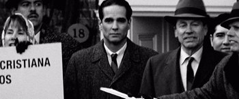 Movie still from “Che: Part One” (2008), directed by Steven Soderbergh – A black and white photo of a man in a suit and tie; Close Up shot, Over the shoulder angle