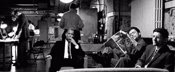 Movie still from “Che: Part One” (2008), directed by Steven Soderbergh – A black and white photo of a man smoking a cigarette; Medium shot, Low angle