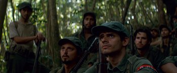 Movie still from “Che: Part One” (2008), directed by Steven Soderbergh – A group of men standing next to each other in the woods; Close Up shot, Low angle