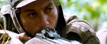 Movie still from “Che: Part One” (2008), directed by Steven Soderbergh – A person with a rifle gun; Close Up shot, Over the shoulder angle
