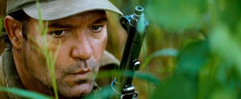 Movie still from “Che: Part One” (2008), directed by Steven Soderbergh – A person holding a gun; Extreme Close Up shot, Low angle