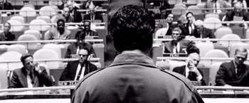 Movie still from “Che: Part One” (2008), directed by Steven Soderbergh – Black and white photograph of a man standing in front of a group of people; Close Up shot, Low angle