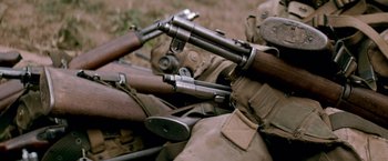 Movie still from “Che: Part One” (2008), directed by Steven Soderbergh – A bunch of guns that are laying on the ground; Extreme Close Up shot, High angle