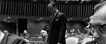 Movie still from “Che: Part One” (2008), directed by Steven Soderbergh – A man in a suit and tie standing in front of another man in a suit and tie; Medium shot, Low angle