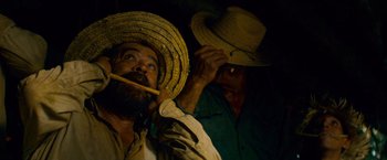Movie still from “Che: Part One” (2008), directed by Steven Soderbergh – A man with a straw hat is holding a pipe; Close Up shot, Low angle