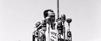 Movie still from “Che: Part One” (2008), directed by Steven Soderbergh – A man standing in front of many microphones; Medium shot, Low angle