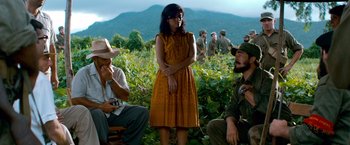 Movie still from “Che: Part One” (2008), directed by Steven Soderbergh – A group of people sitting in a field; Medium shot, High angle