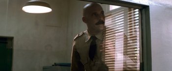 Movie still from “Che: Part One” (2008), directed by Steven Soderbergh – A man with a mustache in a uniform looking in a mirror; Medium shot, Over the shoulder angle