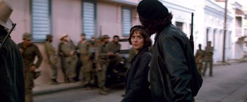 Movie still from “Che: Part One” (2008), directed by Steven Soderbergh – A woman standing next to a man on a street; Medium shot, Over the shoulder angle