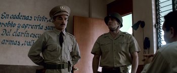 Movie still from “Che: Part One” (2008), directed by Steven Soderbergh – A couple of men standing next to each other in a room; Medium shot, Low angle