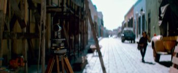 Movie still from “Che: Part One” (2008), directed by Steven Soderbergh – A camera on a tripod in front of a building; Extreme Close Up shot, Low angle