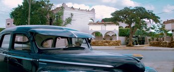 Movie still from “Che: Part One” (2008), directed by Steven Soderbergh – An old car parked on the side of the road; Extreme Wide shot, Low angle