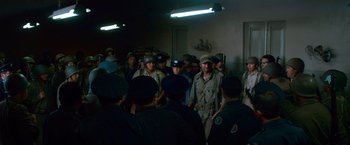 Movie still from “Che: Part One” (2008), directed by Steven Soderbergh – A large group of men in uniform standing in a room; Wide shot, High angle