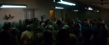 Movie still from “Che: Part One” (2008), directed by Steven Soderbergh – A group of people in helmets and helmets in a room; Wide shot, High angle