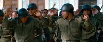 Movie still from “Che: Part One” (2008), directed by Steven Soderbergh – A group of men in military fatigues holding hands; Medium shot, Over the shoulder angle