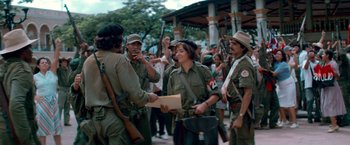 Movie still from “Che: Part One” (2008), directed by Steven Soderbergh – A group of people in military fatigues are gathered together; Medium shot, Over the shoulder angle