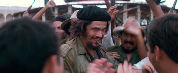 Movie still from “Che: Part One” (2008), directed by Steven Soderbergh – A group of people that are standing together; Close Up shot, Over the shoulder angle