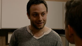 Movie still from “Chernobyl Diaries” (2012), directed by Bradley Parker – A person smiling at the camera; Close Up shot, Over the shoulder angle