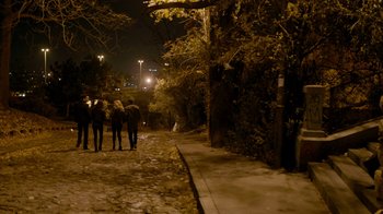Movie still from “Chernobyl Diaries” (2012), directed by Bradley Parker – A group of people walking down a sidewalk at night; Wide shot, High angle