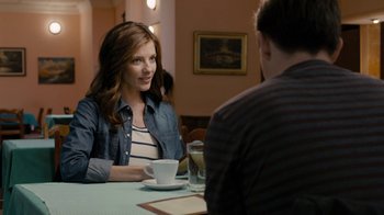 Movie still from “Chernobyl Diaries” (2012), directed by Bradley Parker – A woman sitting at a table in front of a man; Medium shot, Over the shoulder angle