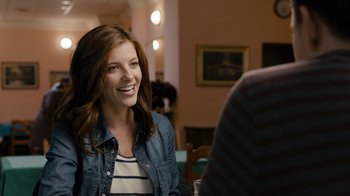 Movie still from “Chernobyl Diaries” (2012), directed by Bradley Parker – A woman sitting in front of a man in a room; Medium shot, Over the shoulder angle